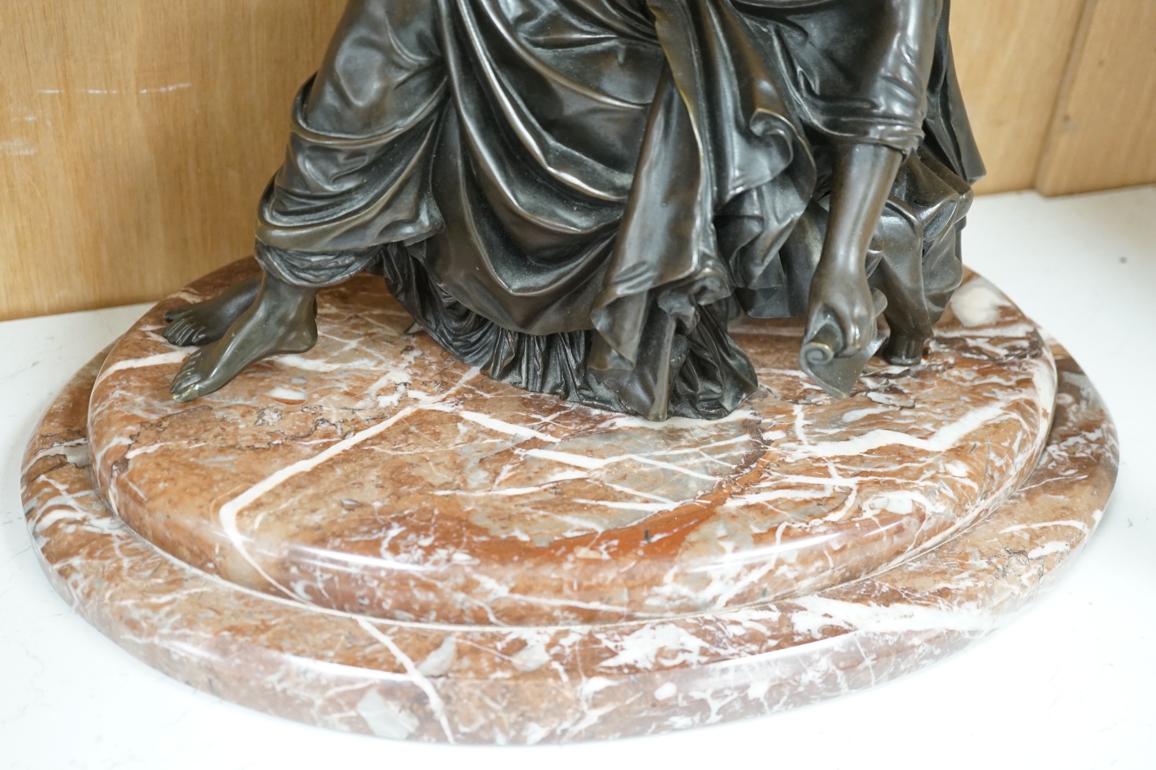 A Continental bronze of a seated young woman on a rouge marble base 37cm wide. Condition - good